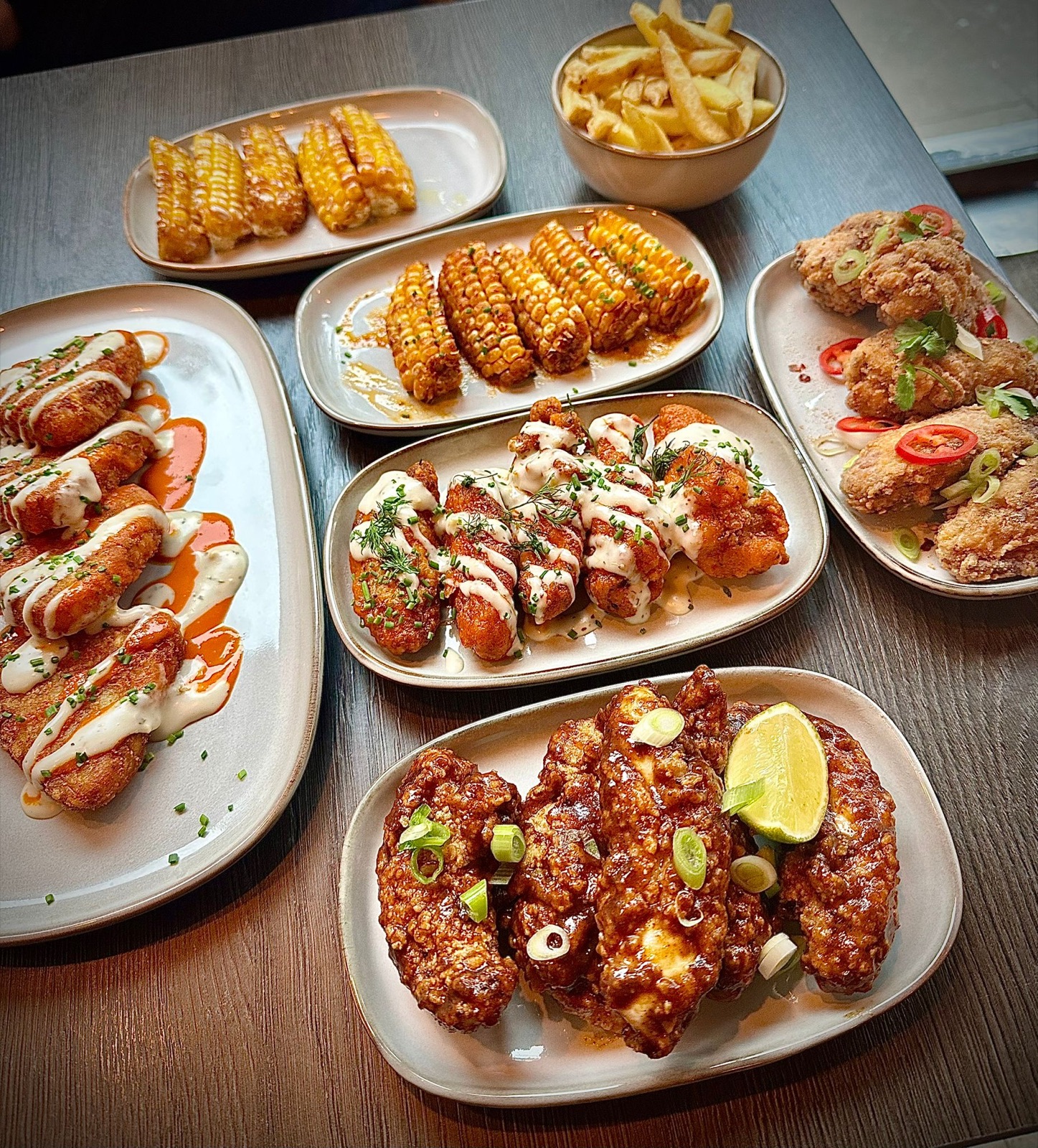 A spread of Bare Bones wings, tenders, corn and fries